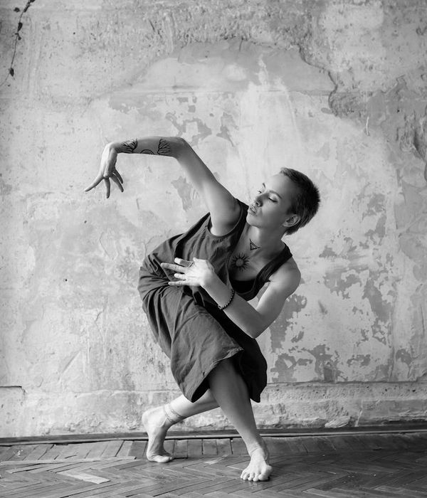 Woman in a fluid motion pose against a clean, minimalist background.